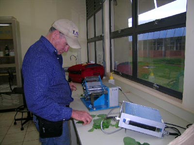 photo showing Dr. Jim Board from Louisiana State University  in the lab putting the leaves through the Leaf Area Meter