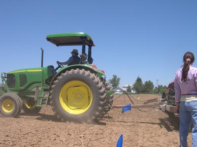 photo of Elena Prior in field monitoring progress during seeding