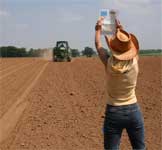 photo showing Elena creating a site point for the tractor operator to fix on for proper row alignment