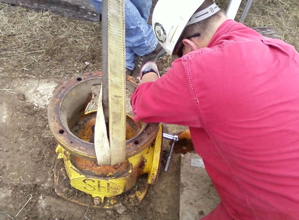 Glynn Beck of the Kentucky Geological Survey works with an existing irrigation well at Murray State University's West Farm. A 140-foot-long section of pipe was pulled from the well so it could be tested for suitability for the new groundwater monitoring network.