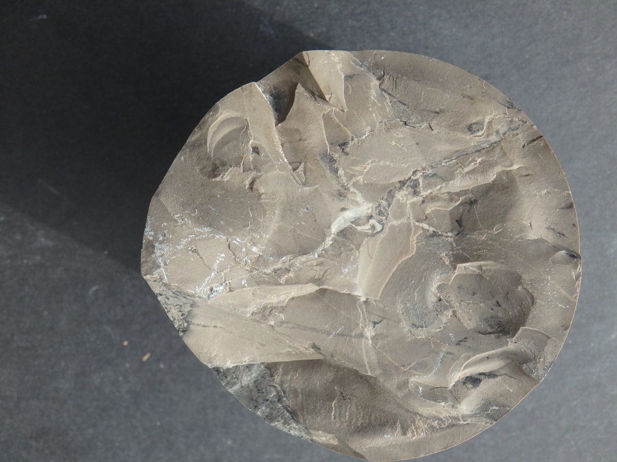 Photo of the butt end of a flint clay (095) core specimen showing the distinctive milky luster and conchoidal fracture.