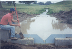Alex Fogle of KGS inspects a new weir dam at UK's Woodford Farm that will be used in studying  water quality.