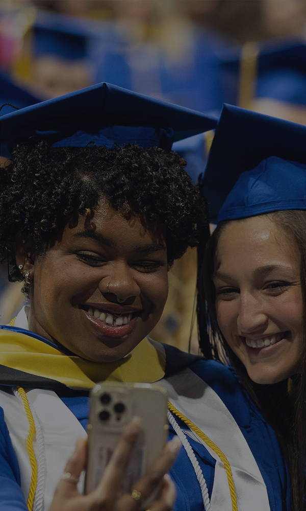 Two female students taking a selfie at graduation