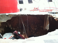 The walls of the hole the cars fell into are just visible under the museum floor.