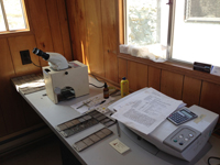 A microscope used in one of the trailers at the well site for examining well samples under white and UV light.