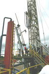 The automatic pipe-handling arm is demonstrated for participants on the tour.