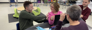 Two deaf children engaging with their teacher.