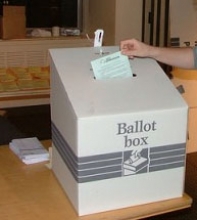 Ballot box with vote being dropped in