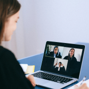Remote employee using laptop on a video call talking to team members