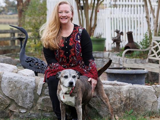 Patient with her dog sitting on a stone fence