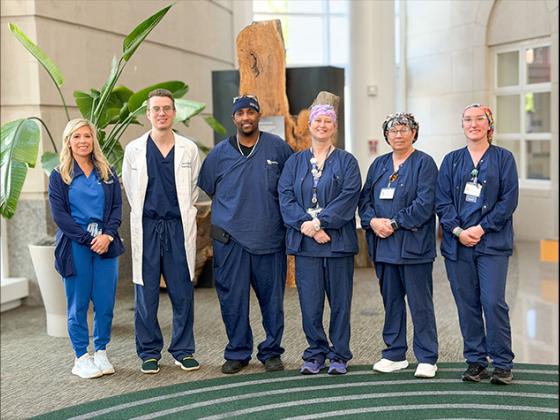 Six members of the robotic kidney transplant team pose for a photo 